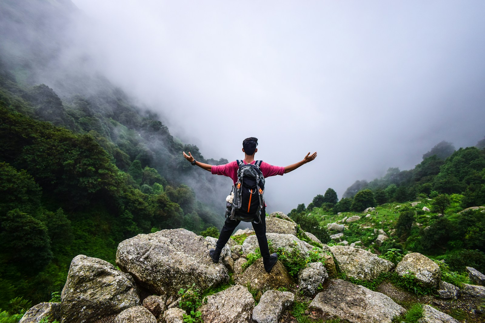 Person standing triumphantly on top of a mountain, symbolizing the journey to stop self-sabotage and achieve personal growth and success.